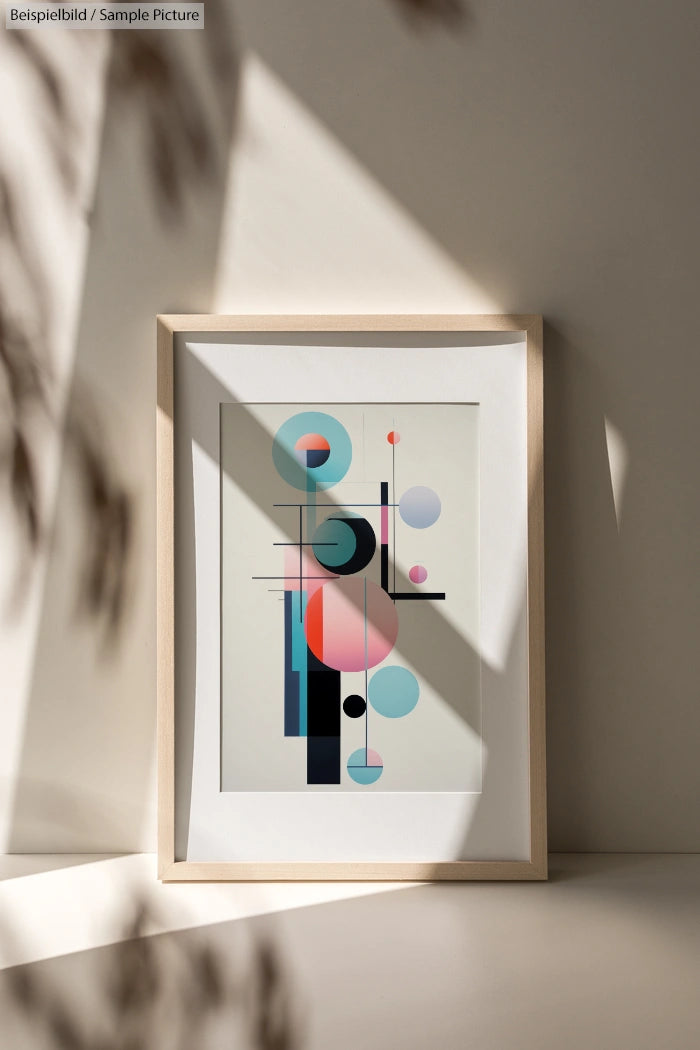 Framed abstract geometric art print with circles and rectangles in pastel colors, displayed against a light wall.