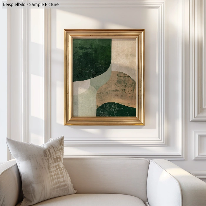 Modern abstract painting with geometric shapes in green, cream, and brown framed in gold, on a white wall above a sofa.