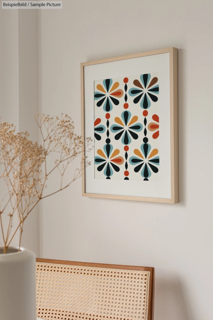 Modern room with a framed abstract floral art print on the wall, and a wicker chair backrest in the foreground.