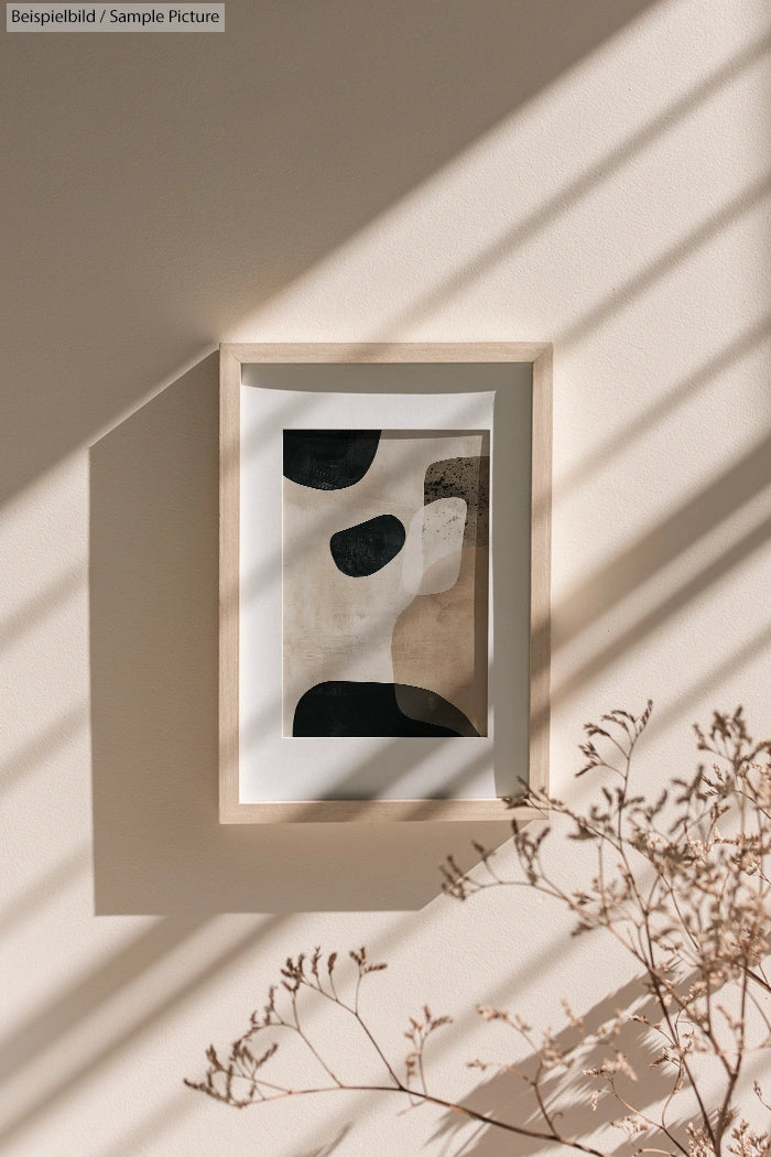 Minimalist abstract painting in wooden frame on wall with shadow patterns and dry foliage.