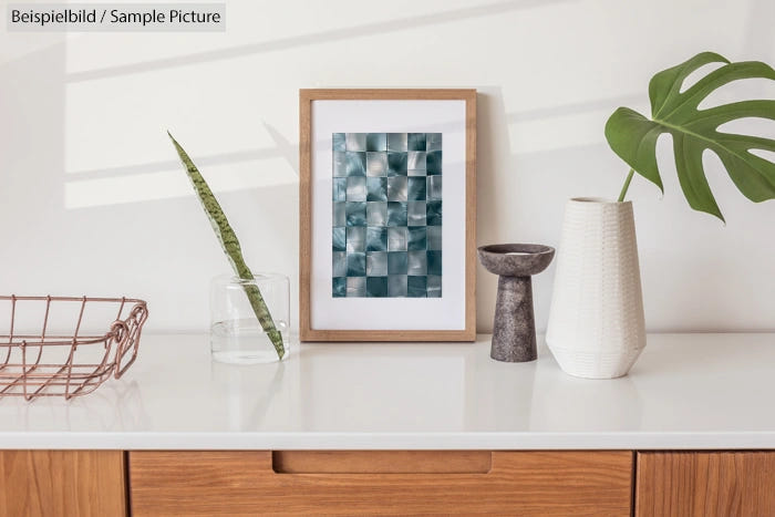 Modern white shelf with decorative vases, framed abstract art, and a potted plant, basked in soft natural light.