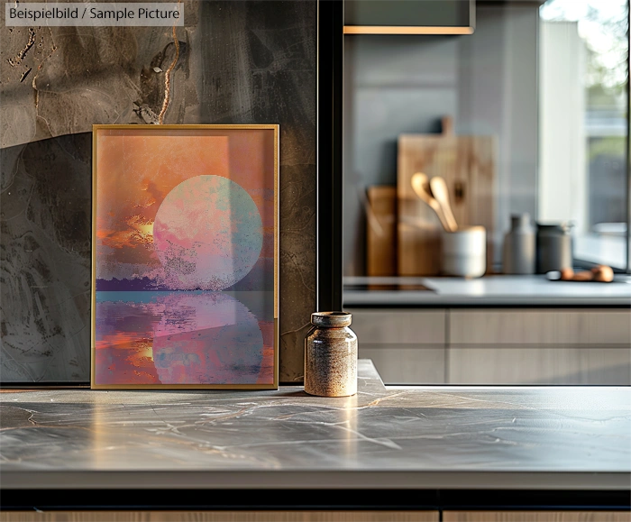 Framed abstract sunset art on modern kitchen countertop with jars and cutting boards in background.