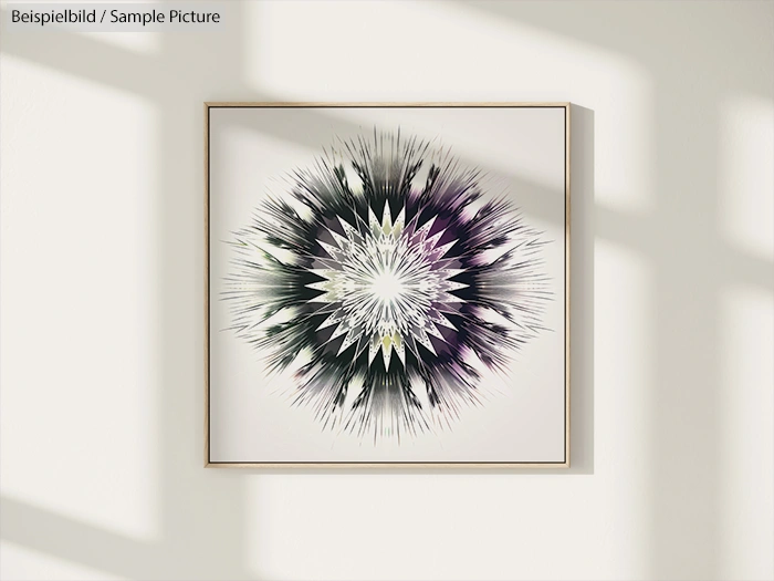 Framed abstract art with a starburst pattern in black, purple, and white on a sunlit wall.