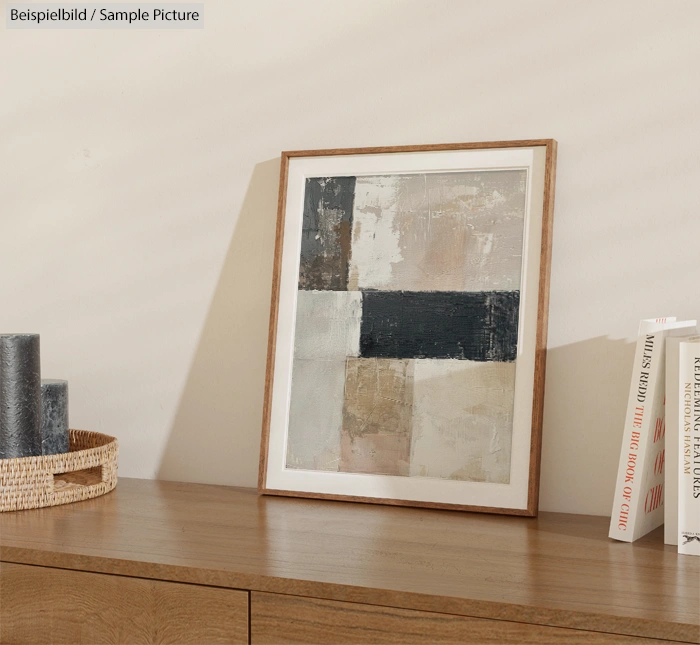 Abstract painting in white and gray tones on wooden dresser with decorative items.