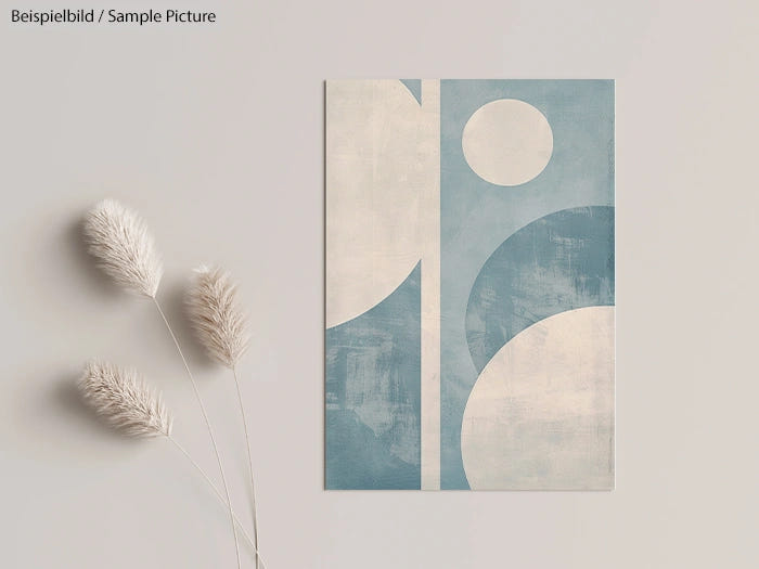 Abstract print with blue and white shapes next to dried plant stems on a light background.