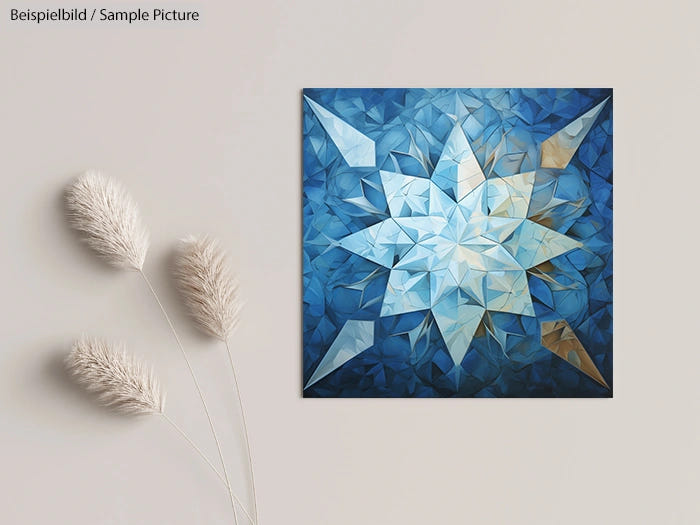 Geometric blue and white star-shaped abstract artwork on a wall next to decorative pampas grass.