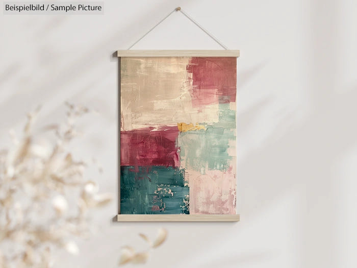 Abstract painting with beige, red, and teal color blocks in a wooden frame, hung on a light-colored wall.