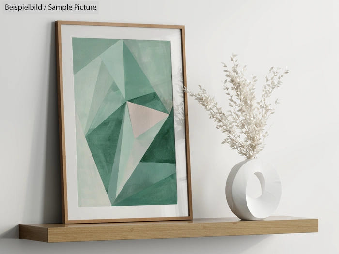 Geometric abstract painting in shades of green, framed on a wooden shelf with a white vase of dried flowers.