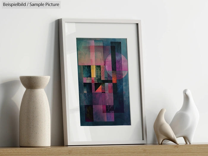 Framed abstract artwork with geometric shapes on a shelf, next to decorative vases and figurines.