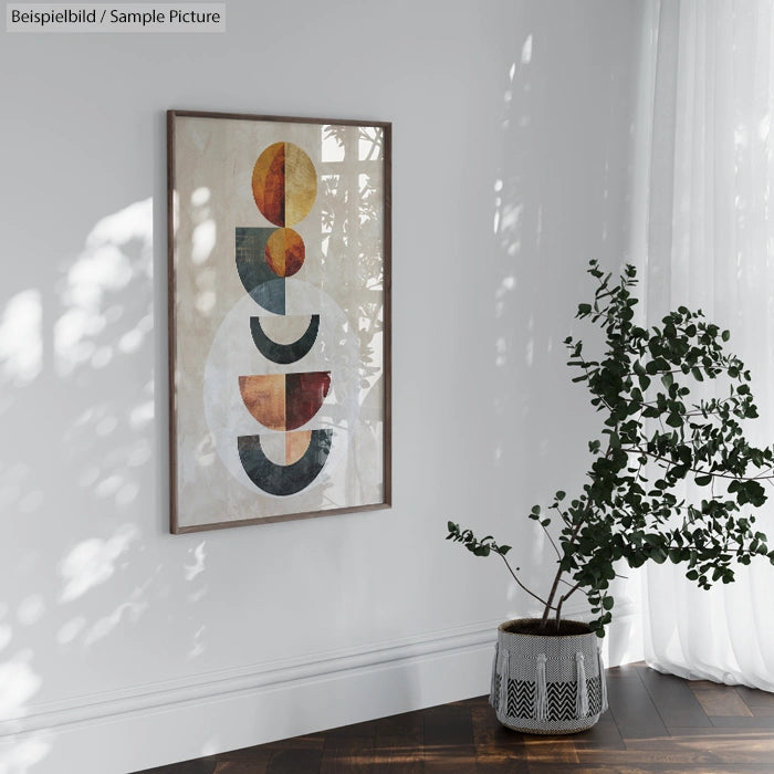 Modern art with geometric shapes on a white wall beside a potted plant near a sheer-curtained window.