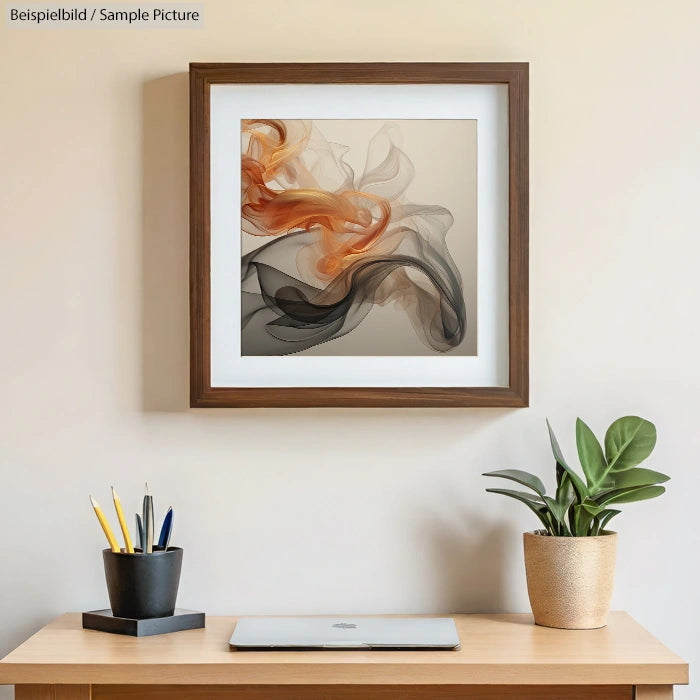 Framed abstract art with orange and black swirls on beige wall above desk with potted plant and pen holder.