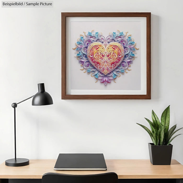 Framed heart-shaped artwork with intricate floral details on a wall above a minimalist desk setup.