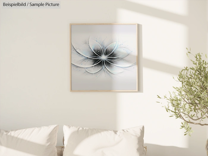 Abstract white and black framed artwork on a light wall above a white sofa with a green plant nearby.