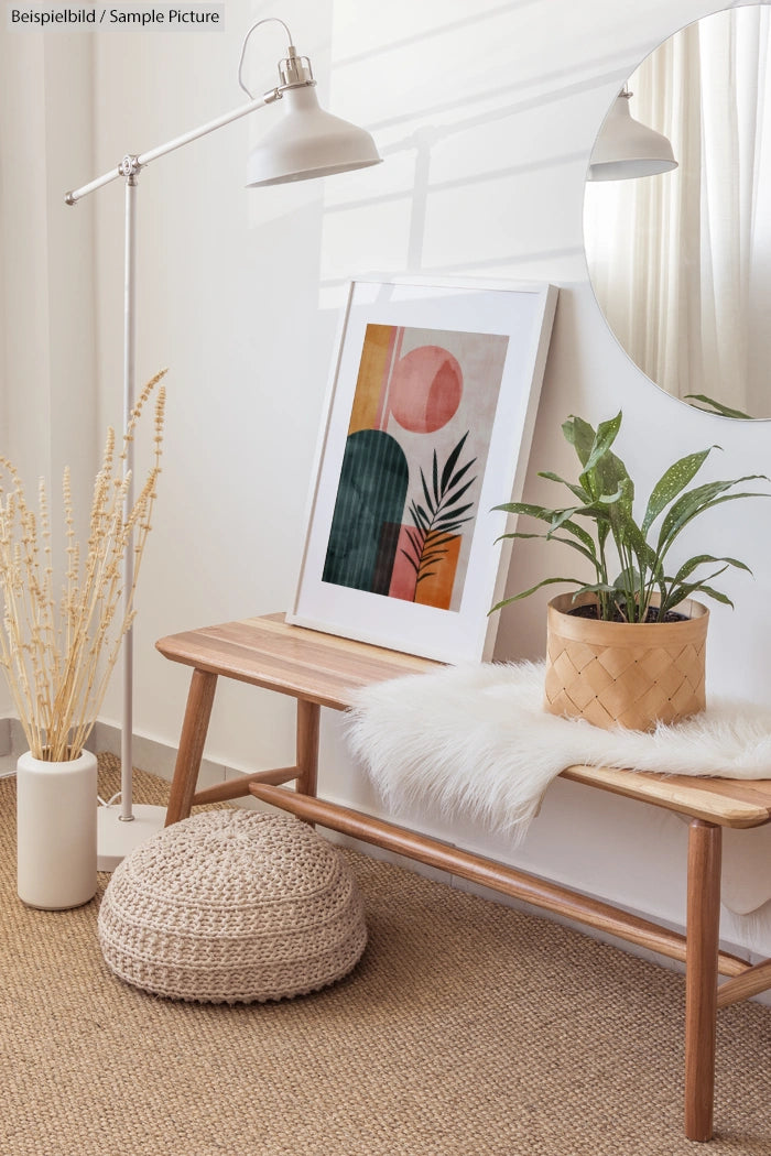 Modern minimalist interior with plant, abstract art, and round mirror on wooden bench.