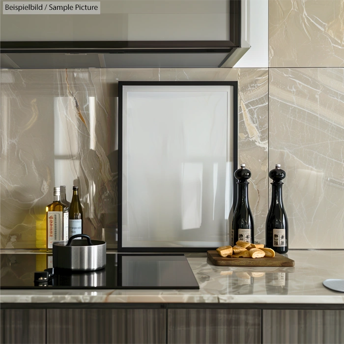 Modern kitchen with marble backsplash, induction cooktop, condiments, and a tray with buns beside salt and pepper mills.