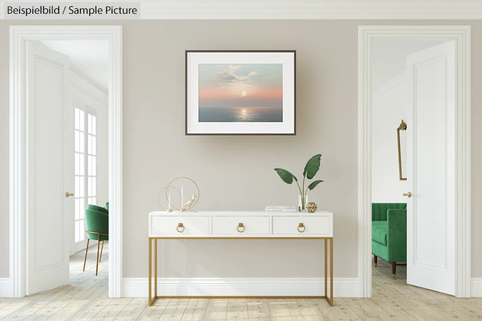 Minimalist hallway with a white console table, plants, and a framed sunset photo on a light gray wall.