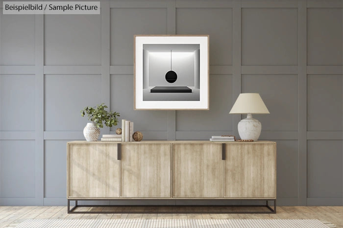 Minimalist living room with wooden sideboard, artwork, table lamp, and potted plant against a paneled gray wall.