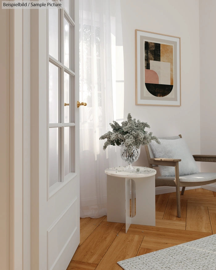 Minimalist living room with wooden floor, white curtains, modern art, and a cozy chair next to a small table with plants.