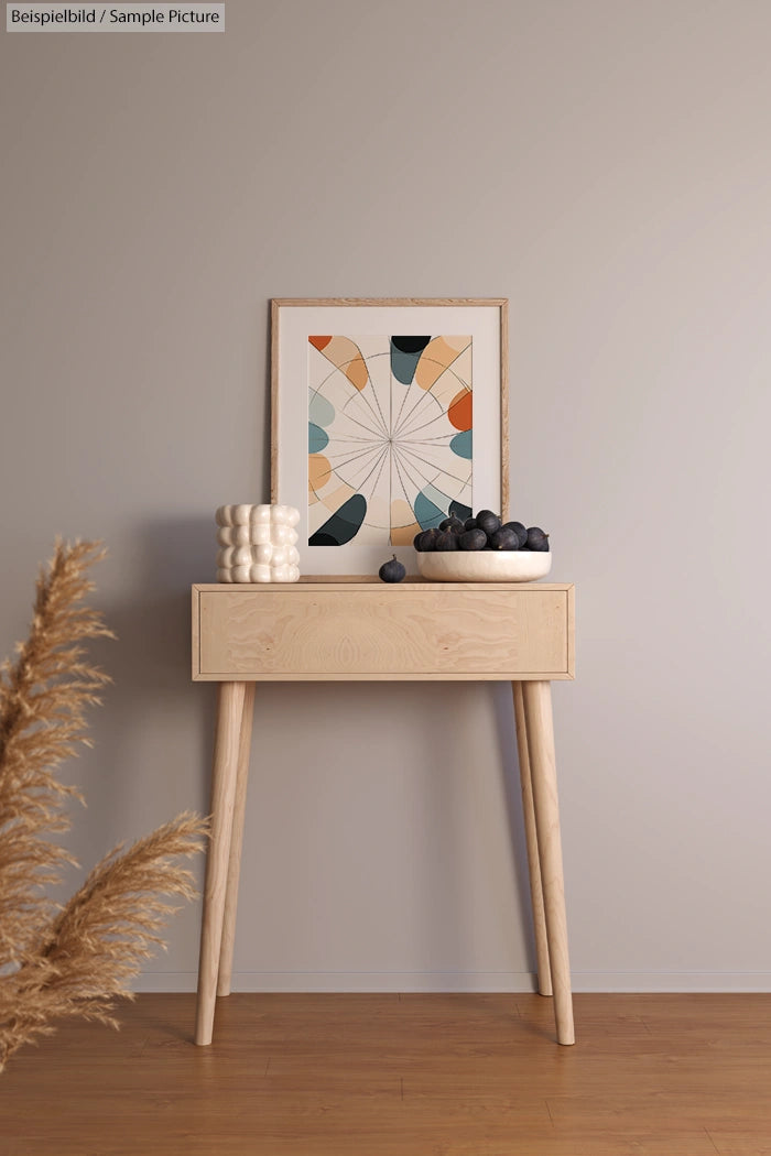 Minimalist wooden table with abstract art, ceramic decor, and a bowl of fruit against a neutral wall.