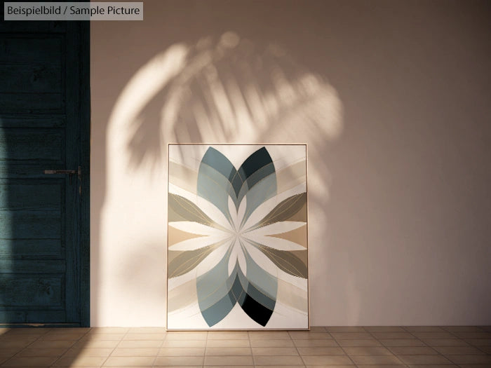 Abstract geometric artwork with symmetrical leaf shapes in muted colors, leaning against a textured wall with soft shadow.