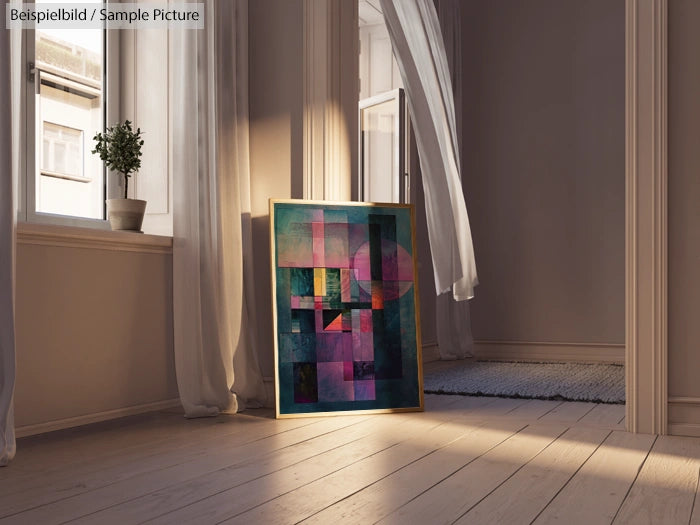 Abstract painting with geometric shapes leaning against a window in a sunlit room.