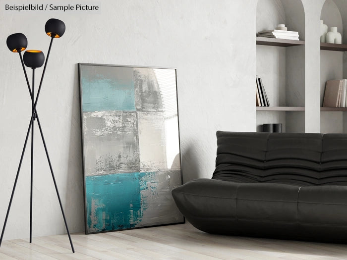 Modern living room with a black leather sofa, abstract painting, and sleek floor lamp against white shelves.