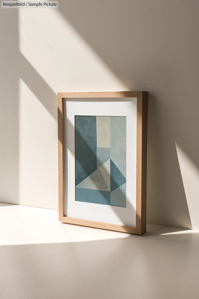 Framed geometric abstract art with light and shadow on a flat surface.