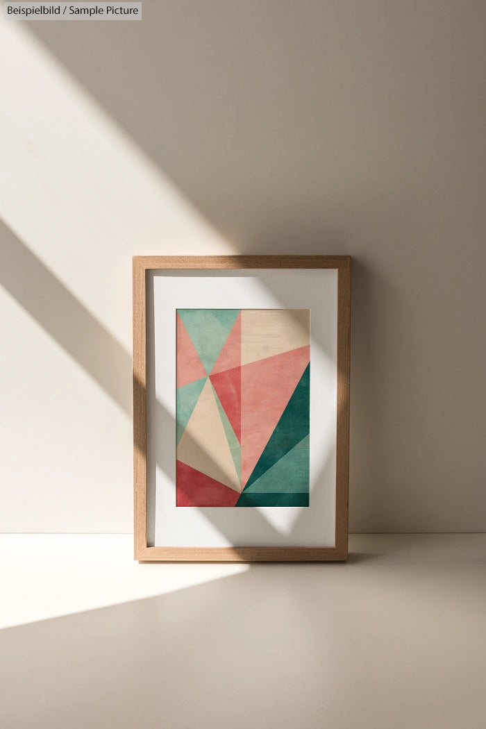 Framed geometric pastel artwork with a wood frame, featuring angled shapes in sunlight on a minimalist background.