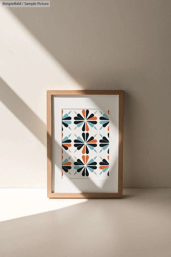 Minimalist room with framed geometric artwork of teal, orange, and black shapes on a light background.