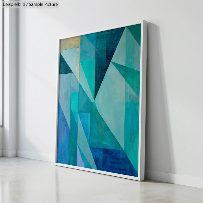 Abstract geometric painting with blue and teal shapes on canvas, leaning against a white gallery wall.