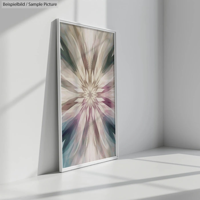 Framed abstract artwork with starburst pattern in pastel colors, displayed against white interior wall.