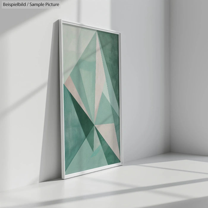 Modern geometric art in shades of green and white, framed and leaning against a white wall with soft shadows.