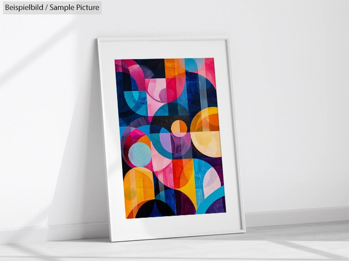 Framed abstract art print with colorful geometric patterns leaning against a white wall.