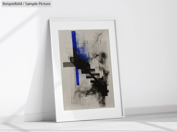 Framed abstract art with black and blue geometric lines, leaning against a white wall.