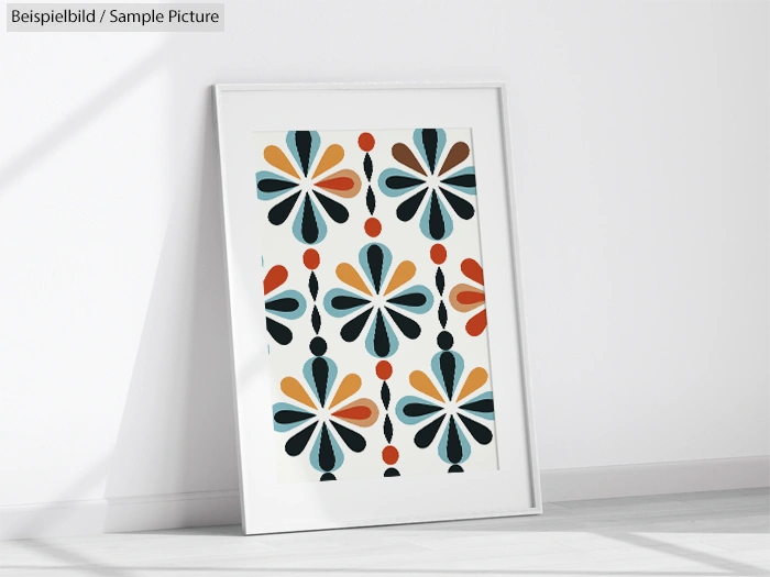 Framed retro artwork with colorful abstract flower pattern leaning against a wall.