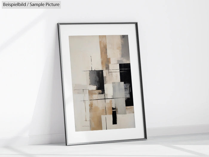 Framed abstract geometric painting with beige, black, and white rectangles leaning against a white wall.