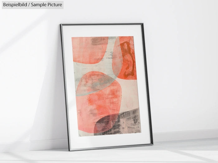 Framed abstract art with red and orange geometric shapes, displayed against a white wall.