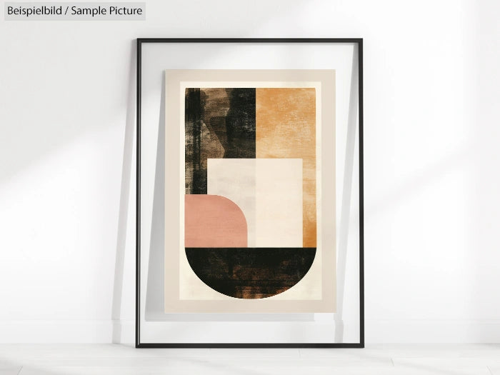 Framed abstract art with geometric shapes in black, pink, and beige, leaning against a white wall.