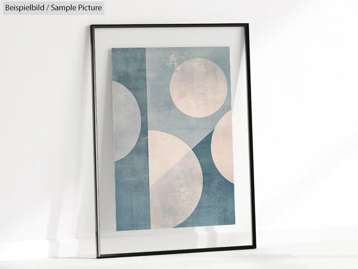 Framed abstract art with blue and white geometric shapes, including circles and triangles, on a textured background.