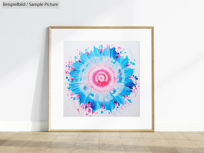 Framed abstract painting with blue and pink floral burst on white wall.