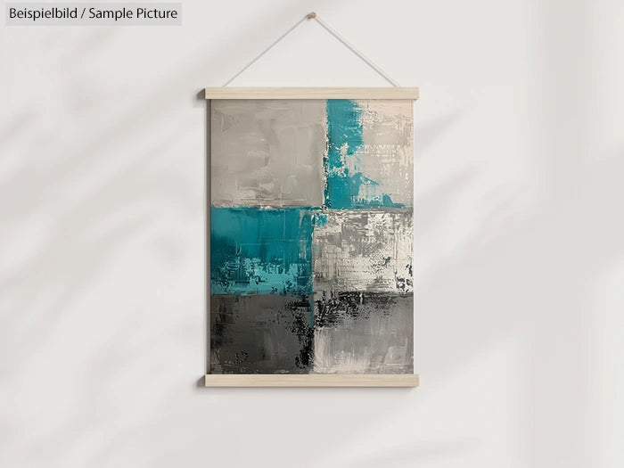 Abstract painting in teal, gray, and black with geometric blocks, displayed in a wooden frame hanging on a light wall.