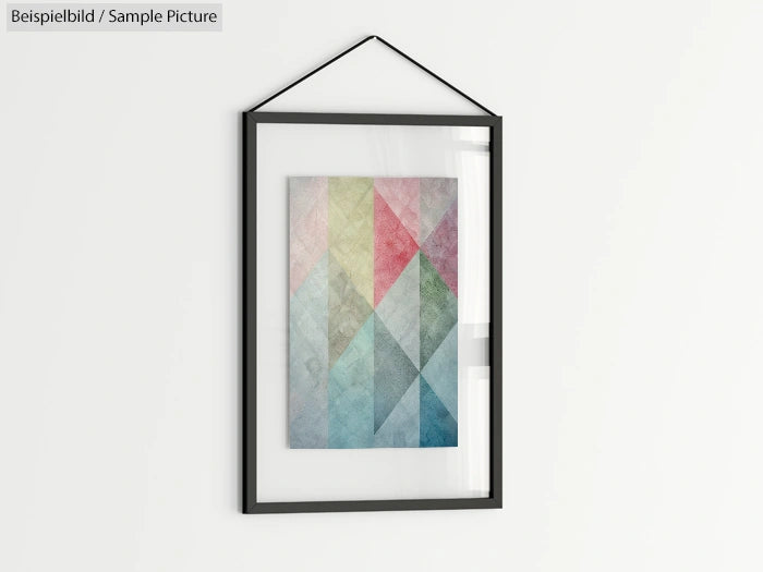 Framed abstract artwork with colorful geometric patterns and diagonal shapes on a white wall.