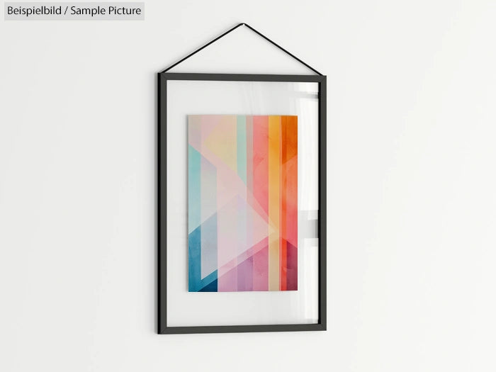 Framed abstract art with pastel geometric shapes in a modern black frame hanging on a white wall.