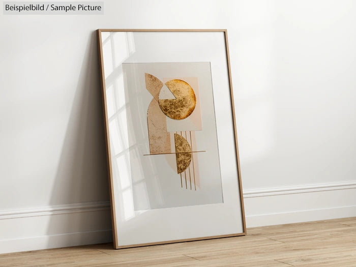 Abstract art print with geometric shapes in beige and gold, framed and leaning against a white wall on wooden floor.