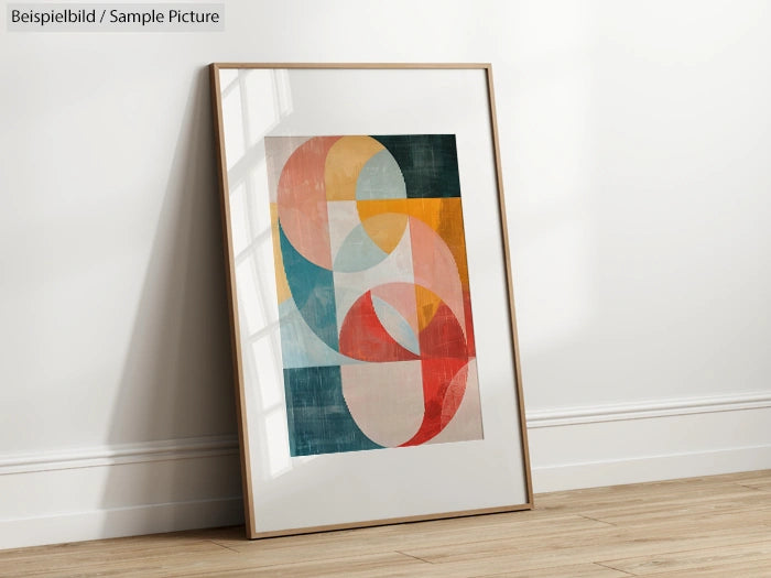 Framed abstract art print leaning against a white wall, featuring colorful geometric shapes and curves.