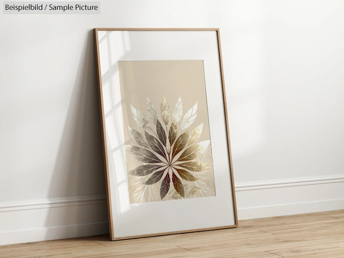 Framed botanical print with layered leaves in neutral tones, leaning against a white wall on a wooden floor.