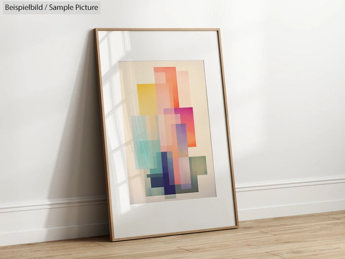 Framed abstract art with colorful overlapping rectangles leaning against a white wall on a wooden floor.