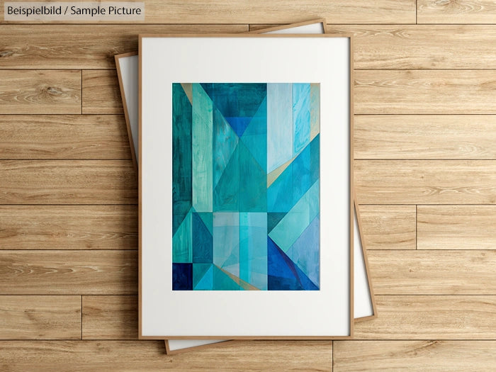 Geometric abstract artwork with shades of blue and green, framed, on a wooden floor background.