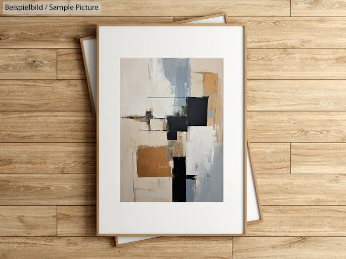 Abstract painting with geometric shapes in beige, gray, black, and white, framed on a wooden floor.