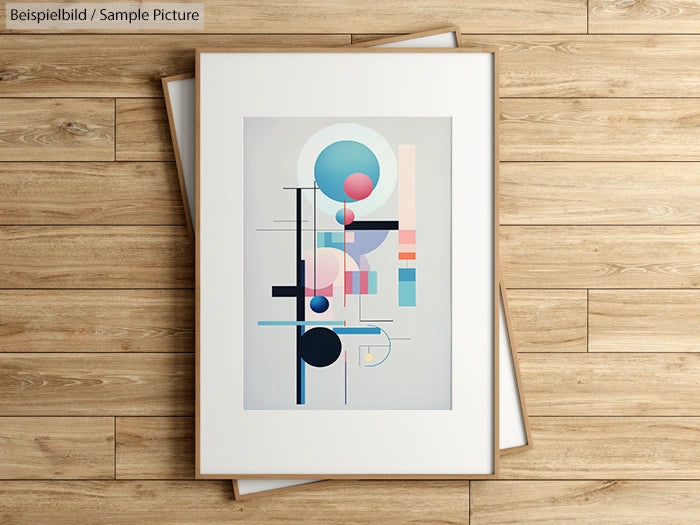 Geometric abstract art with circles and lines in pastel colors on framed artwork on wooden floor.